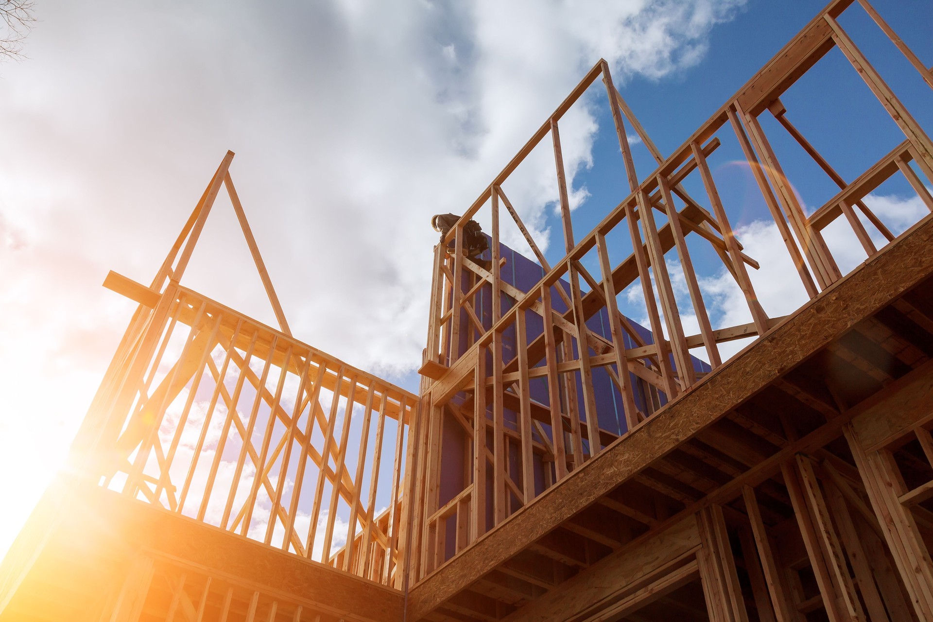 builder at work with wooden roof construction Wood Building frame